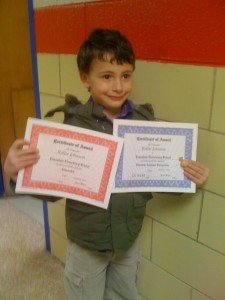 Rollie First Grade Honors Day Here is the proud little guy, holding up his awards. He took the unibomber jacket off for the actual ceremony and walking across the stage. Small victories.