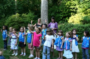 Doing the girl scout pledge thingie with the three fingers. Tiller is beside the kid in the pink shirt.