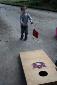 Boys focused on cornhole and that jumpie thing.